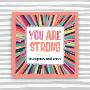 Colorful framed artwork with motivational quote on a striped background